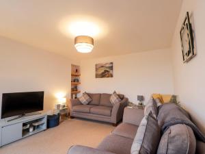 a living room with a couch and a flat screen tv at Nanville in Beauly