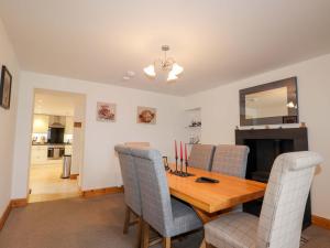 a dining room with a wooden table and chairs at Nanville in Beauly