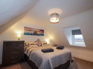 a bedroom with a bed and a dresser and a window at Nanville in Beauly