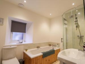 a bathroom with a tub and a toilet and a sink at Nanville in Beauly +25 photos