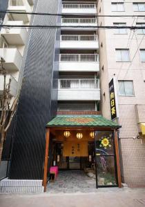 a building with a entrance with a pink chair at Hotel 向日葵 in Osaka