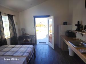a bedroom with a bed and a kitchen with a sliding door at Sunrise Springs in Pahrump