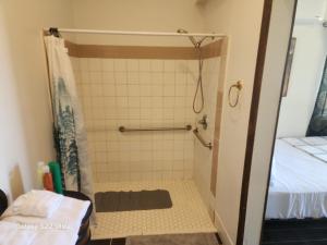 a shower stall in a bathroom with a bed at Sunrise Springs in Pahrump