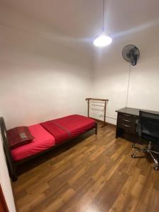 a small room with a red bed and a desk at Anggerik Camelia Homestay Apartment Ladang Tok Pelam FREE WIFI in Kuala Terengganu