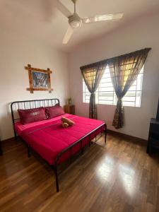 a bedroom with a red bed with a teddy bear on it at Anggerik Camelia Homestay Apartment Ladang Tok Pelam FREE WIFI in Kuala Terengganu