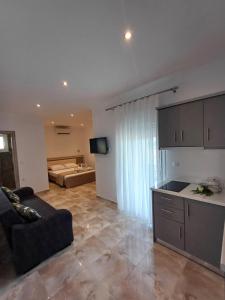 a living room with a couch and a kitchen at Summer Paradise in Paralia Sikias