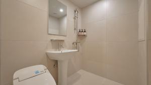 a white bathroom with a toilet and a sink at Maison de Centum Busan in Busan +64 photos