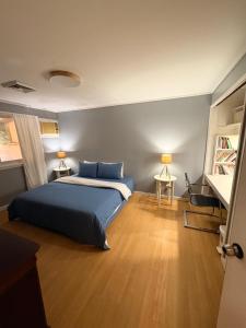 a bedroom with a blue bed and a wooden floor at A Pet Friendly Subic Bay Vacation Home in Olongapo