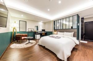 a bedroom with a large white bed and a desk at STYLE Hotel in Seoul