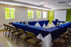 a row of blue tables and chairs in a room at Hotel Gardenia Inn in San Salvador +44 photos
