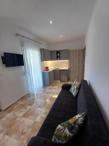 a living room with a couch and a kitchen at Summer Paradise in Paralia Sikias