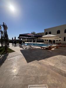 a swimming pool with a umbrella and a building at Ark hotel PREMIUM in Bukhara