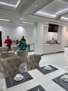 a dining room with a table and people in the kitchen at Ark hotel PREMIUM in Bukhara +56 photos