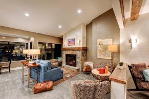 a living room with a blue couch and a fireplace at Garrison Hotel & Suites Dover-Portsmouth, an Ascend Collection Hotel in Dover
