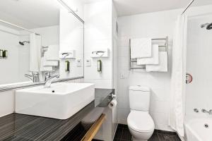 a white bathroom with a sink and a toilet at Hotel Elms Christchurch, an Ascend Collection Hotel in Christchurch