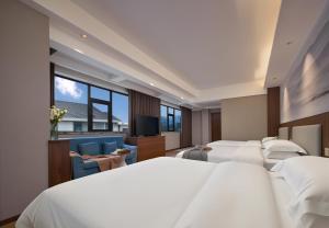 a hotel room with two beds and a large window at Zhangjiajie Zhenxi Hotel- Near Forest Park EastGate about 10 Min Walk - English Butler, Free Luggage Storage, Tour Plan -reserve tickets for various scenic spots-Self-Service Laundry,Free coffee, Chinese tea in Zhangjiajie +103 photos