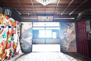 a room with a door with paintings on the walls at minshuku studio enishi in Nagahama