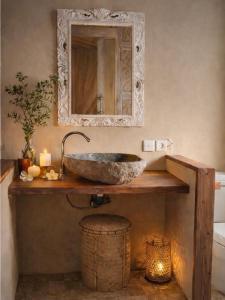 a bathroom with a stone sink and a mirror at Greengo Private POOL VILLA in Gili Meno