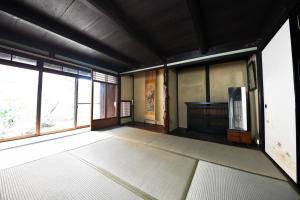 an empty room with a large window and a piano at minshuku studio enishi in Nagahama