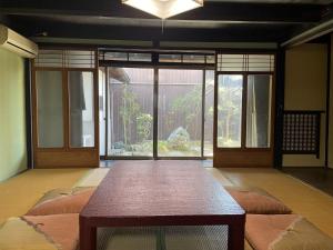 a room with a table and a large window at minshuku studio enishi in Nagahama