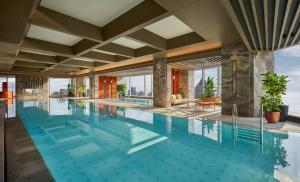a large pool with blue water in a building at Andaz Shanghai ITC in Shanghai