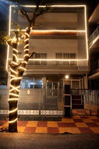 a tree in front of a building with lights at Super Hotel Pari Chowk Formerly The Divine KRC in Greater Noida +7 photos