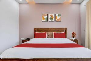 a bedroom with a large bed with red pillows at Super Hotel Pari Chowk Formerly The Divine KRC in Greater Noida
