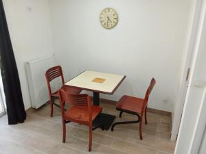 a table and chairs with a clock on the wall at EVASION LOUE #6 x2 people "La BRIQUERIE" in Lods