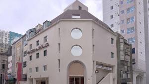 a building with a clock tower on top of it at Maison de Centum Busan in Busan