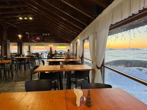 a restaurant with tables and chairs in the snow at Cabana Rares in Ranca