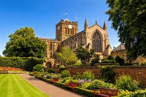 an old church with a clock tower and a garden at Market View 1 in Hexham