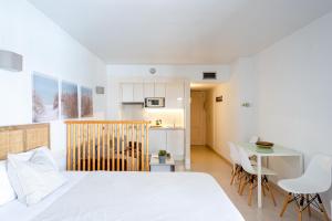 a bedroom with a bed and a table and a kitchen at nice seafront apartment in Almuñécar +22 photos