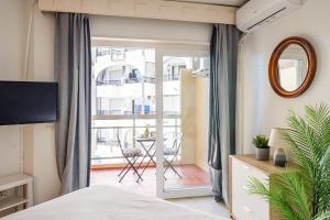a bedroom with a bed and a balcony with a table at nice seafront apartment in Almuñécar