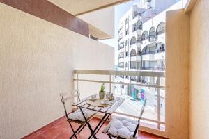 a balcony with a table and chairs and a building at nice seafront apartment in Almuñécar