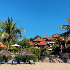 a resort with chairs and umbrellas on the beach at Poshanu Boutique Resort in Mui Ne