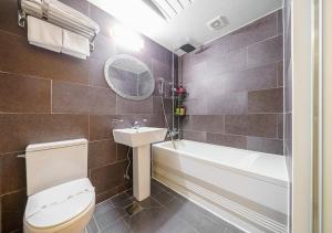 a bathroom with a toilet and a sink and a bath tub at Ilsan Hotel K in Goyang +28 photos