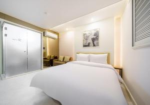 a bedroom with a large white bed in a room at Ilsan Hotel K in Goyang