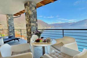 a balcony with a table and chairs and a view at Residence degli Oleandri 6A in Argegno