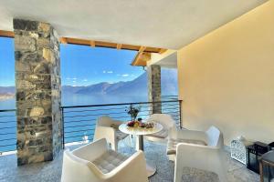 a room with a table and chairs on a balcony at Residence degli Oleandri 6A in Argegno