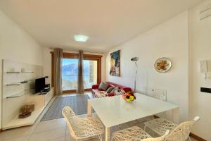 a living room with a white table and chairs at Residence degli Oleandri 6A in Argegno