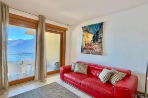 a red couch in a living room with a window at Residence degli Oleandri 6A in Argegno +15 photos