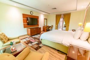 a hotel room with a bed and a tv at Hotel One Faisalabad in Faisalabad