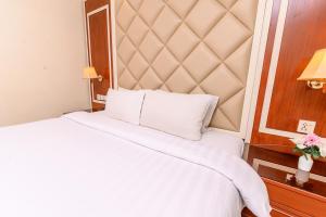 a bed in a hotel room with a large headboard at Hotel One Faisalabad in Faisalabad