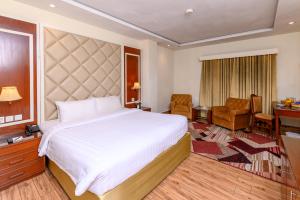 a hotel room with a large bed and a desk at Hotel One Faisalabad in Faisalabad +24 photos