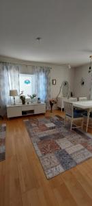 a large living room with a table and a rug at Omakotitalo Pirintie 22, Härmä in Kauhava