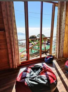 a room with a large window looking out at the ocean at wood house vattakanal in Kodaikānāl