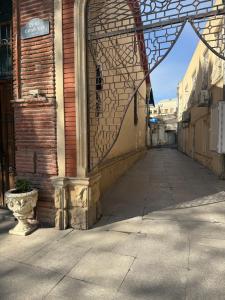 an empty alley with a brick building with a window at Уютная комната in Ganja