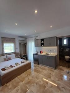 a large bedroom with a large bed and a kitchen at Summer Paradise in Paralia Sikias