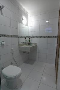 a white bathroom with a toilet and a sink at Skala Traveling Hotel in Cuiabá +16 photos