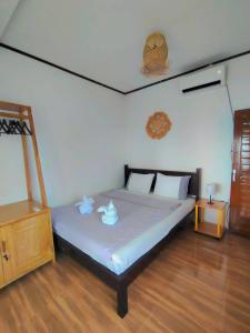 a bedroom with a bed with two pillows on it at Bunaken Paradise Beach Homestay in Bunaken